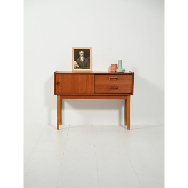Scandinavian teak and oak entryway cabinet from the 1960s, featuring storage and drawers, recessed handles, and an...