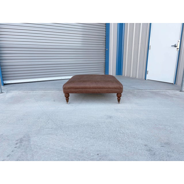 Mid-century leather ottoman designed and manufactured in the United States, circa 1970s. This generously scaled ottoman...