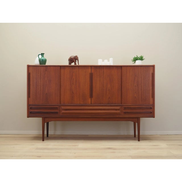 The highboard was made in the 1960s, Danish production. The structure is covered with teak veneer. The legs and handles...