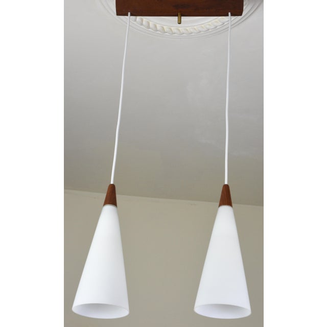 A beautiful and unusual vintage danish trompet two-light pendant / chandelier, designed for fog & mørup. the trompet first...
