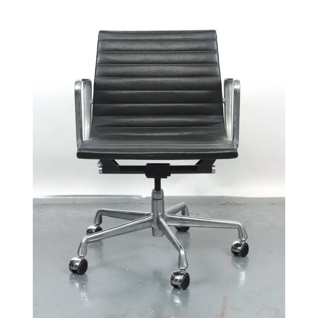 Attributed to Herman Miller Eames Aluminum Group Chair designed by Charles and Ray Eames. The black leather upholstery is...