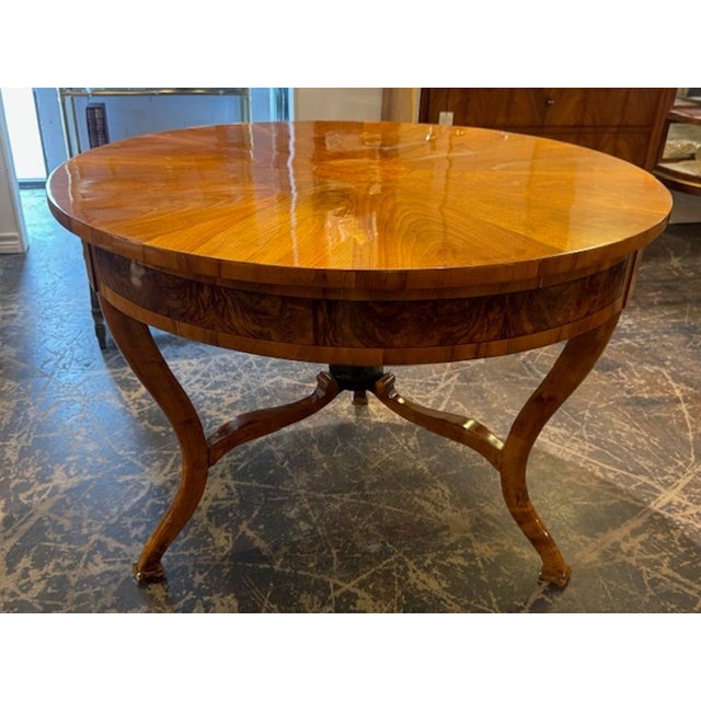This 19th century German walnut Biedermeier center table is a timeless piece of antique furniture that exudes elegance and...