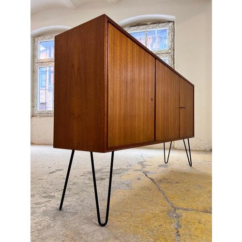This teak sideboard from rt Möbel is a classic example of West German mid-century furniture design. The frame impresses...
