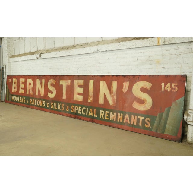 Reclaimed movie set sign made of aluminum in red, green, and white colors. The sign reads "145, Bernstein's, Woolens &...