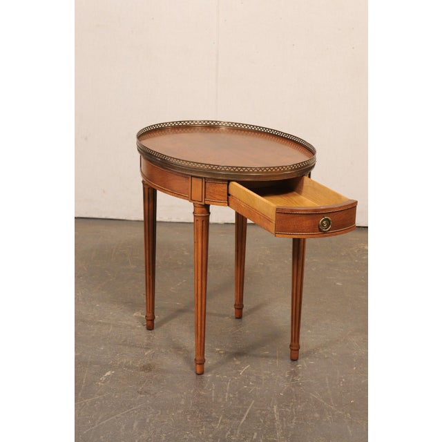 A French accent or side table with brass gallery edge top, from the mid 20th century. This vintage smaller-sized table...