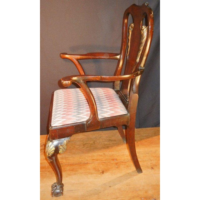 This pair of antique arm chairs in the George II style, in mahogany and mahogany veneer, have superior hand-carved and...