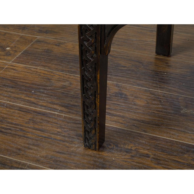 A set of 12 Moroccan ebonized wood armchairs from circa 1900 with carved décor and leather seats and backs. Crafted with...