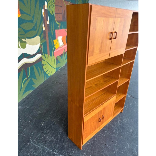 Classic Danish teak bookcase with its sleek, minimalist design and ample storage. Great narrow profile to fit in many...
