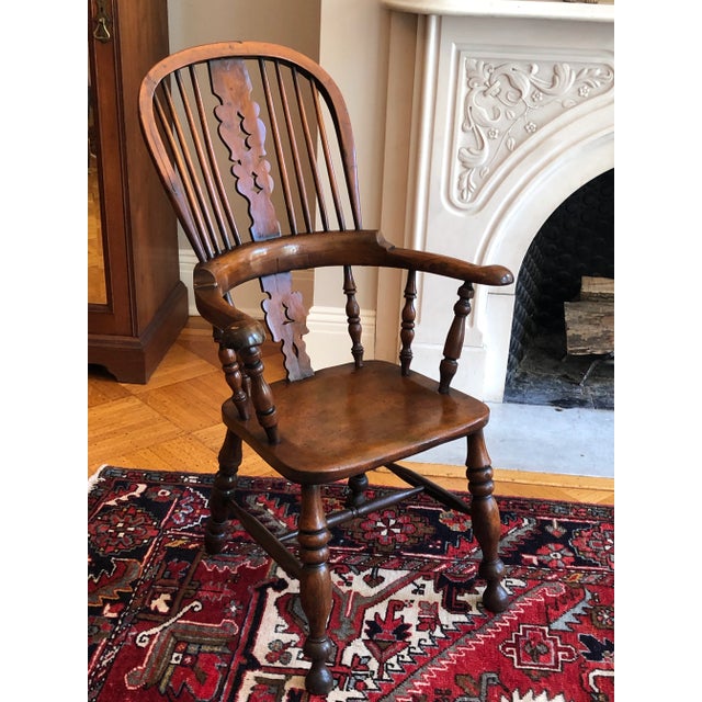 Offering a large and beautiful antique English Yew Tree Windsor arm chair with a tall bentwood hooped back, pieced central...