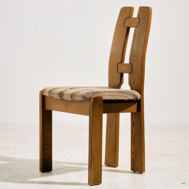 Solid oak dining chair with sculptural backrest and comfortable textile upholstery from the 1980s. with some surface...