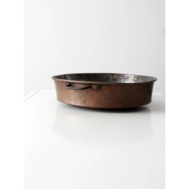 Antique moulded copper braising pan with iron handles and an aged tin lining. Beautifully hammered with a rich, time-worn...