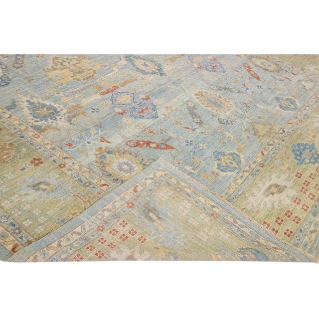 Beautiful modern Sultanabad hand-knotted wool rug with a blue field. This Sultanabad rug has a green frame and multicolor...
