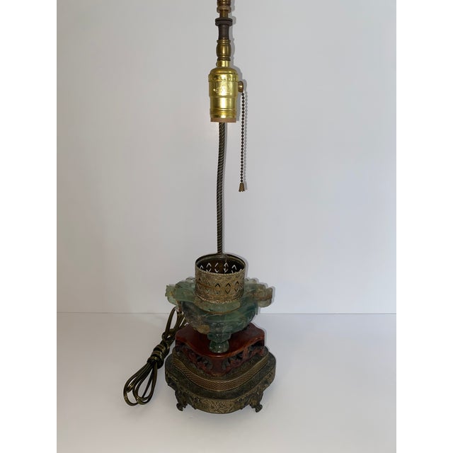 Carved jade color fluorite lamp mounted on wood and brass base. Lamp holds small bulb to light the interior of the vase...