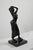 Bronze with brown patina representing a young woman, dressed in a long dress, with a swaying look. This protagonist,...