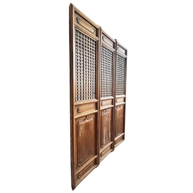 Beautiful antique set of three solid elm wood screen doors. Lattice cut out top portion with traditional carved designs on...