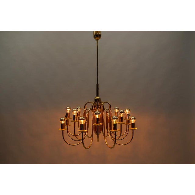 Lovely elegant mid-century modern brass chandelier lamp, italy 1970s executed in glass, metal and brass. The lamp needs 16...