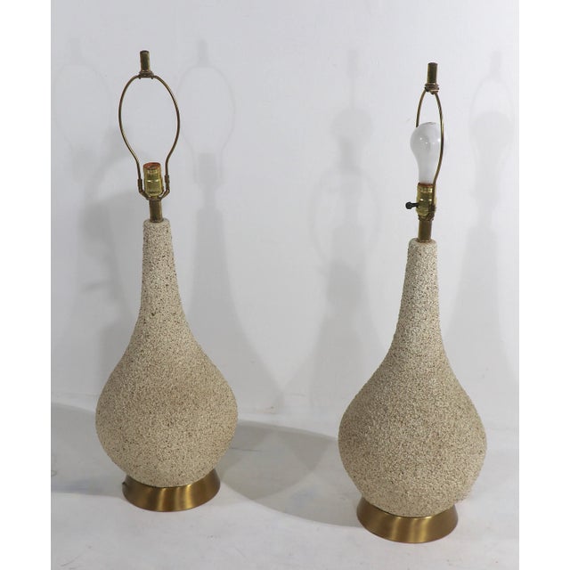 Chic pair of Mid Century ceramic table lamps, of bulbous form, having dimensional textured surfaces, mounted on brass...