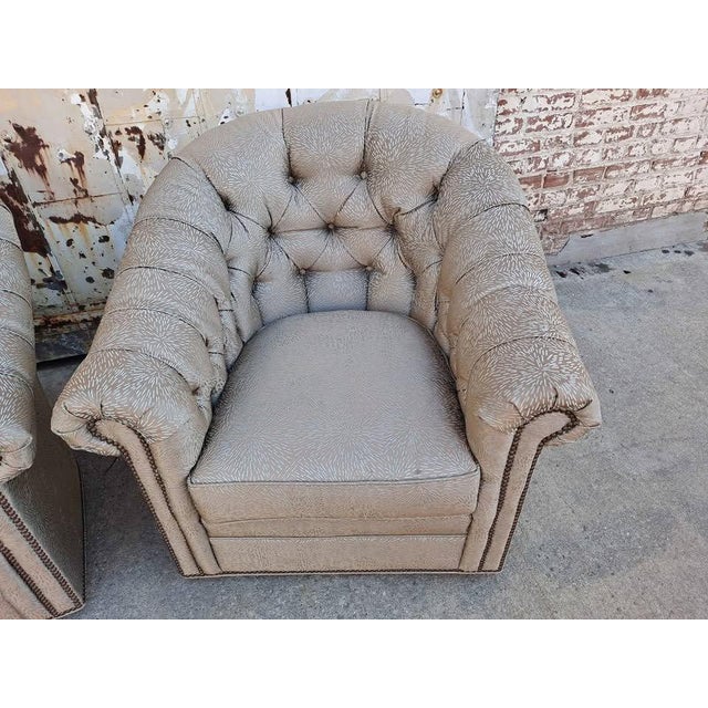 A stylish pair of custom Lexington Robinson swivel lounge chairs featuring a classic tufted back design with rolled arms,...