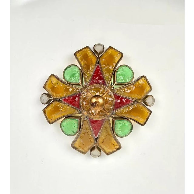 Three-light wall lamp sconce in golden iron and colored glass by Longobard. Made in Italy in the 1970s. The color of the...