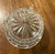 This is a clear glass, three footed dish intricately designed with prominent diamond and starburst patterns. It features a...