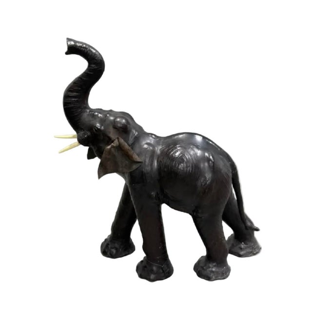 Impressive monumental leather elephant sculpture standing 47 inches high, featuring a dramatic raised trunk and commanding...