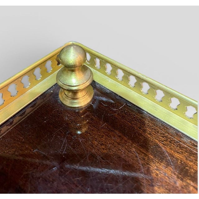 Sophisticated French Louis XVI style lacquered wood corner table with intricate brass metalwork sides. Three turned brass...