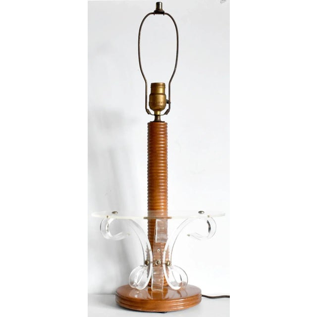A vintage, mid-century modern table lamp with a grooved spindle wood column and base and a clear acrylic shelf held up...