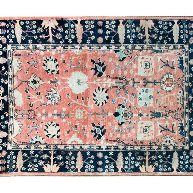 This vintage Indian wool rug, hand-knotted in the late 20th century, draws inspiration from the classic Persian Sarouk...