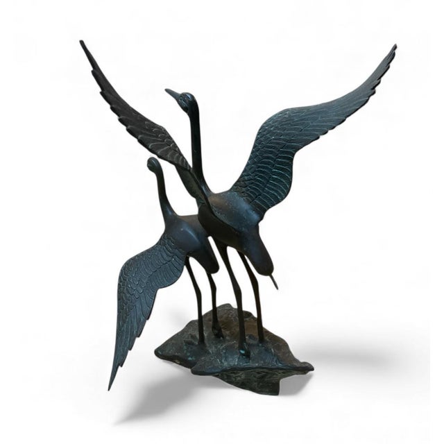 This vintage bronze sculpture captures a pair of graceful cranes (or herons) in a dynamic, life-like pose. One bird is...