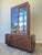 Striking Lane Brutalist display cabinet crafted in rich walnut, featuring bold geometric carved details, glass display...