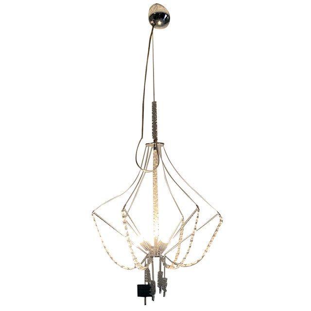 Suspension chandelier featuring cascading Swarovski crystals. Three light sources are positioned at the center of the...