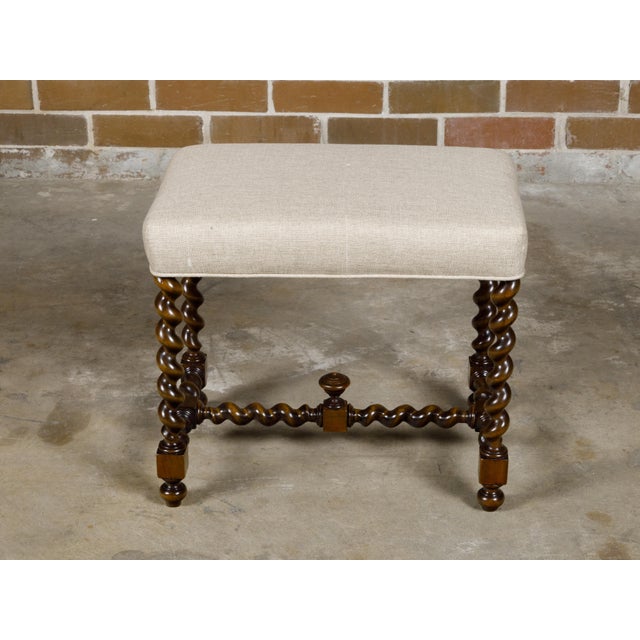An English oak barley twist stool from the 19th century with cross stretcher and custom linen upholstery. This oak stool,...