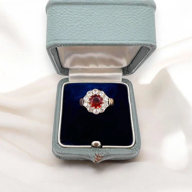 Antique daisy ring in 14 carat gold (585 thousandths) from the 1910s. It is decorated with a central spessartite garnet of...