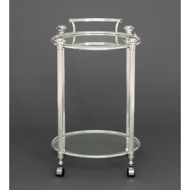 Modern Chrome Plated Two-Tier Bar Cart, the circular glass top with removable glass serving tray on four casters. Overall:...