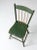 Antique primitive chair with a rustic plank seat, spindle back, and graceful splay legs. The aged green painted finish,...