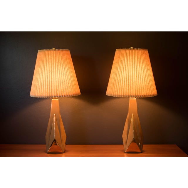 Pair of vintage sculptural ceramic pottery table lamps circa 1950's. This unique set features a a glossy tan finish with...