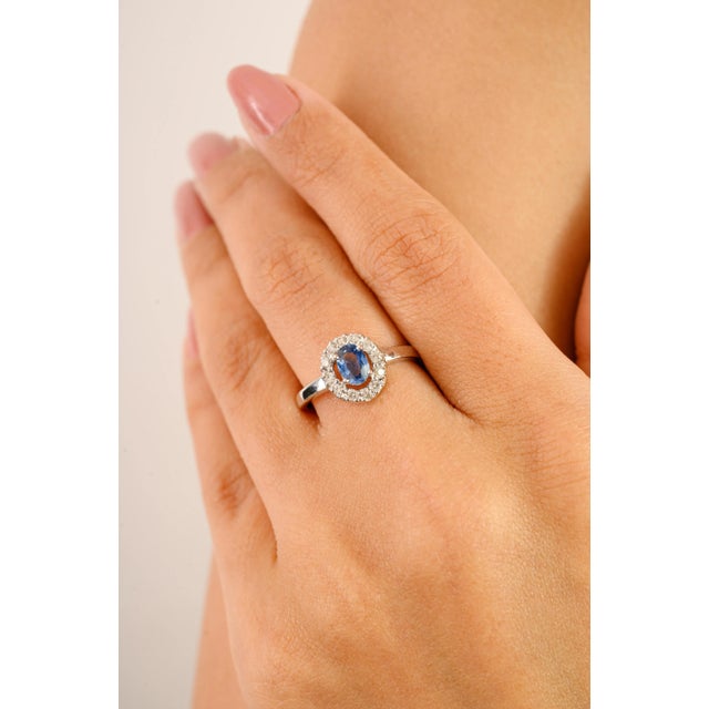 A timeless expression of elegance, this exquisite ring features a 0.62 carat oval-cut sapphire set at the center,...