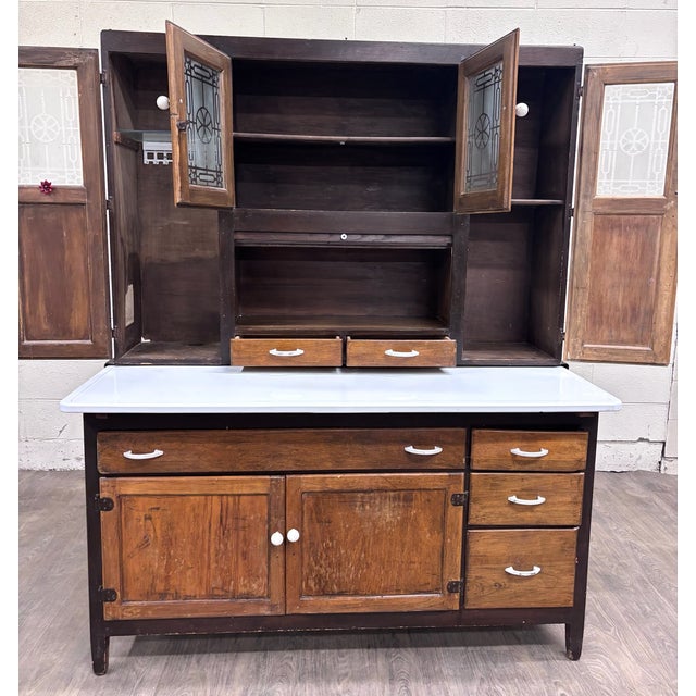 This is a stunning antique farmhouse Hoosier-style wooden kitchen cabinet from the early 20th century, featuring...