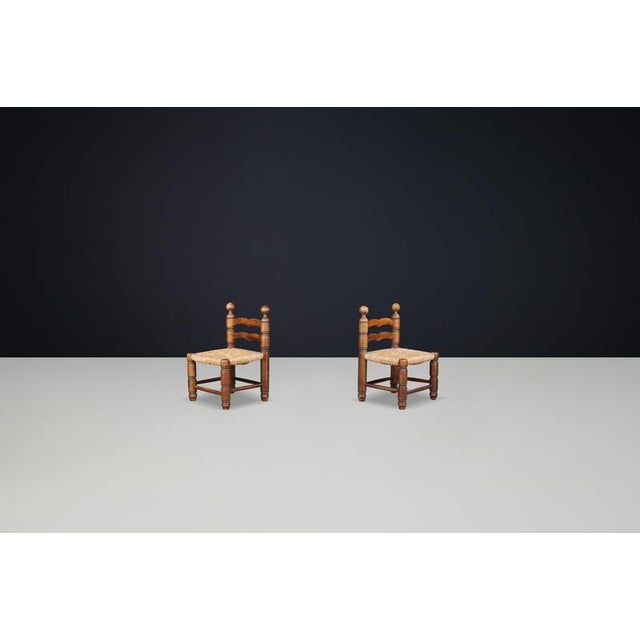 Charles Dudouyt fireplace chairs, made from beech wood and featuring rush seats, France, 1940s. A pair of Charles Dudouyt...