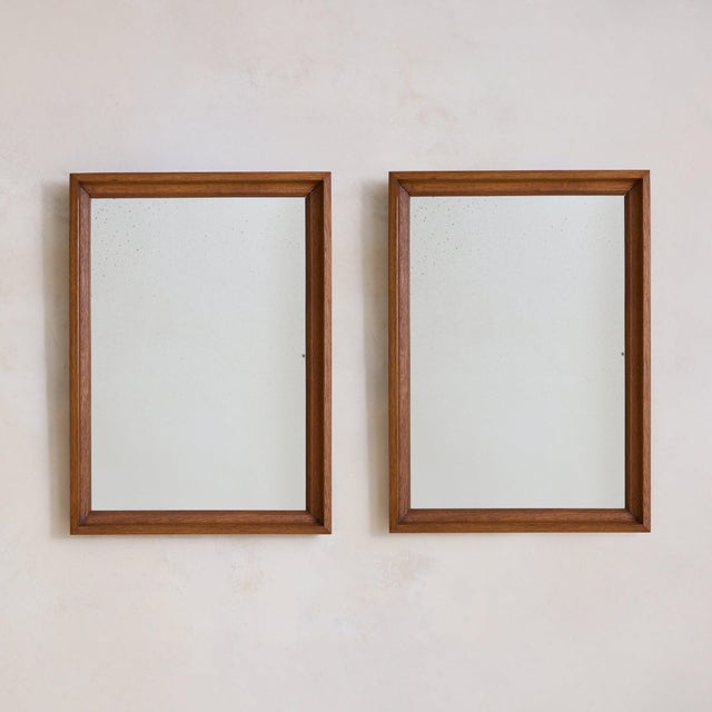 A 1940s French wall mirror framed in warm, patinated wood. The rectangular silhouette is understated yet thoughtfully...