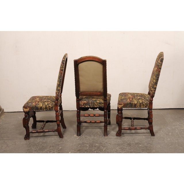 A French set of six Renaissance style carved wood and upholstered side chairs from the early 20th century. These antique...