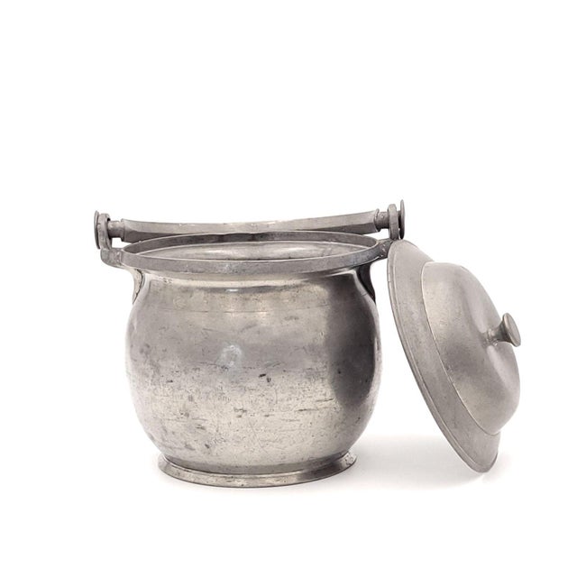 A set of three pewter porringers, circa 1800. Dents, wear and tear, one without lid. Listed measurements are for the...