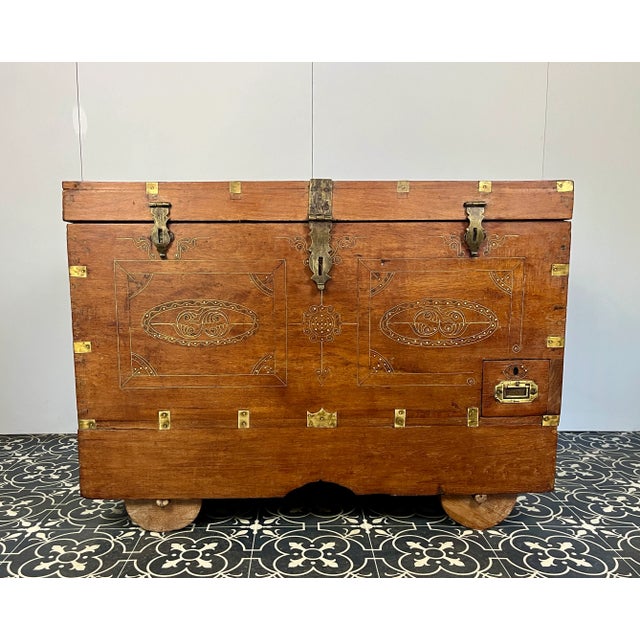 A beautiful Anglo-Indian Marriage Dowry chest circa 1900 with campaign handles and original wooden wheels, a very well-...