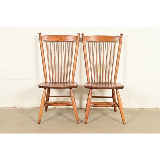 A gorgeous pair of American Colonial or Arts & Crafts style solid oak spindle back Windsor side chairs or dining chairs In...