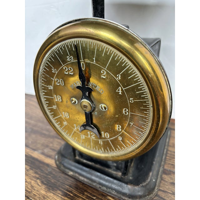 Antique brass-face scale mid-20th century with soldier carrying the American flag on the sides and a porcelain top.