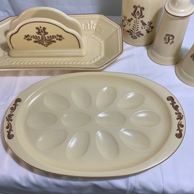 These are vintage Pfaltzgraff "Village" pattern stoneware table and serving pieces featuring a dark brown folk-art floral...