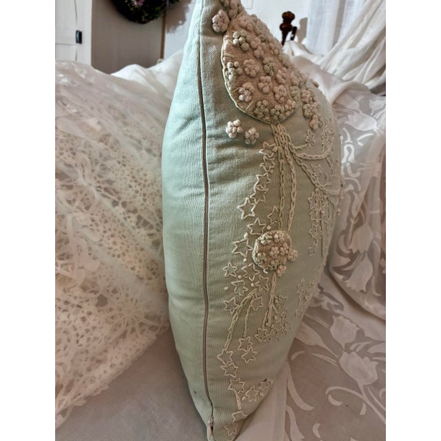 A mint green Tahari Home embroidered floral throw pillow. It features an intricate botanical pattern created with a...