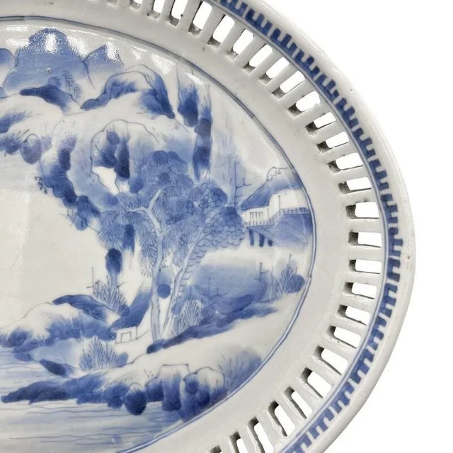 An antique Japanese Seto porcelain plate from the Meiji period. Reticulated and decorated rim surrounding a mountain scene...