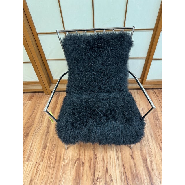 Tibetan wool upholstery adds a plush counterpoint to the slender frame of our 1970s-inspired chair. The spare, tubular...