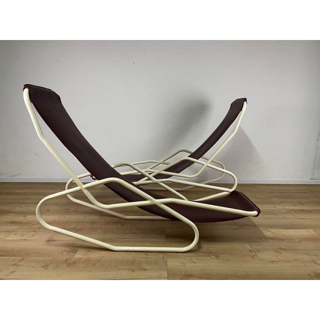 Pair of large deck chairs with a white painted woven iron frame and burgundy leather seat, made in Italy in the 1950s. The...